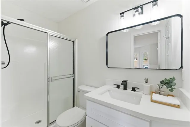 a bathroom with a sink vanity mirror and toilet