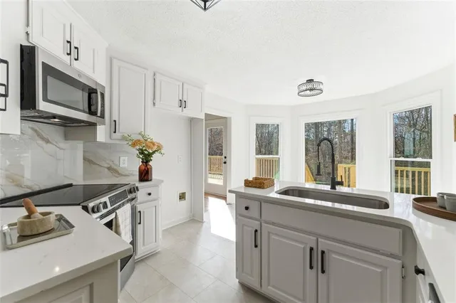 a kitchen with stainless steel appliances a sink stove and microwave