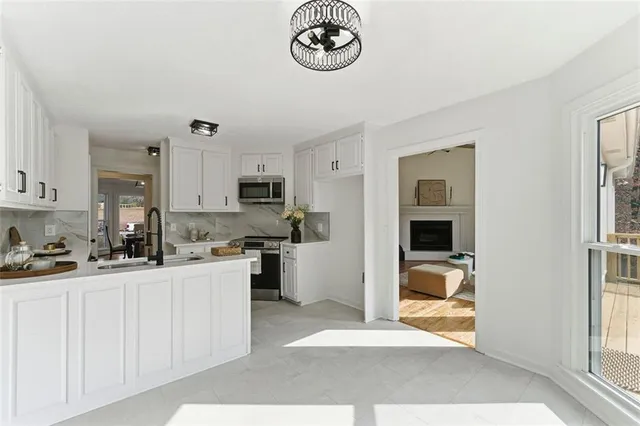 a kitchen with white cabinets and appliances