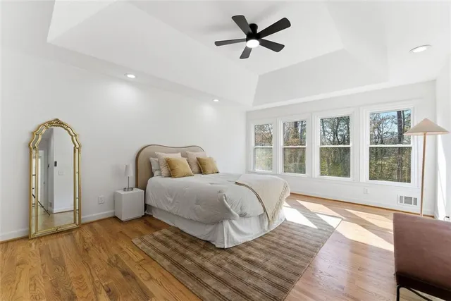 a spacious bedroom with a large bed and wooden floor