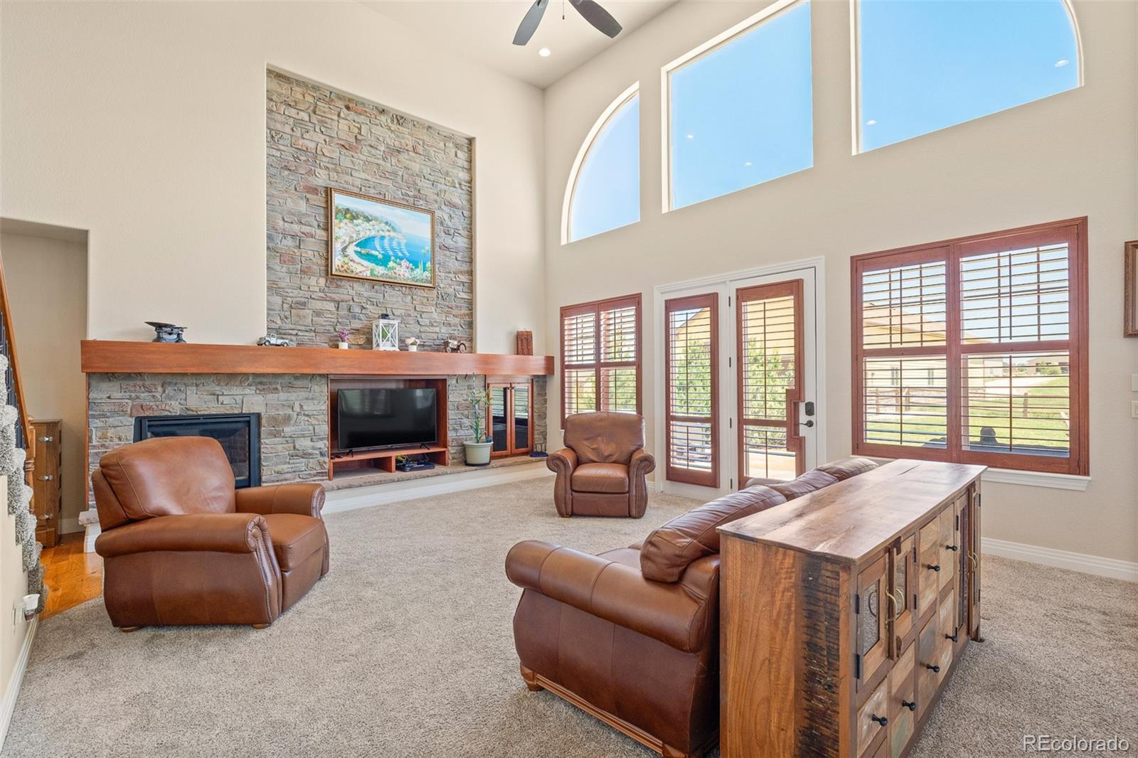 41865 East Muirfield Loop Elizabeth, CO 80107 - Photo 9 of 50 a living room with furniture a fireplace and a large window