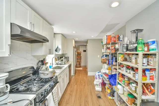 a kitchen filled with lots of clutter and stainless steel appliances