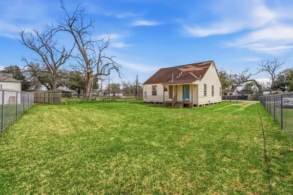 a front view of house with yard and trees in the background