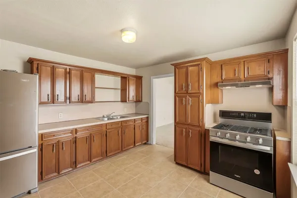 a kitchen with stainless steel appliances granite countertop a stove a sink and a refrigerator