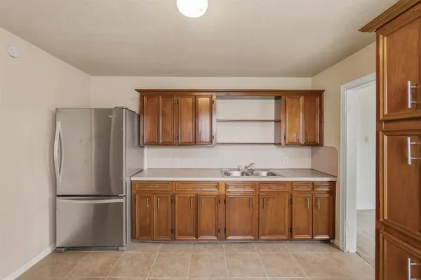 a kitchen with a sink a refrigerator and cabinets