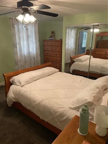 a bedroom with a bed and dresser with mirror