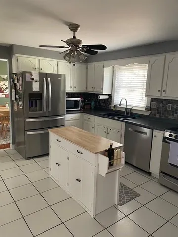 a kitchen with granite countertop a refrigerator and a sink