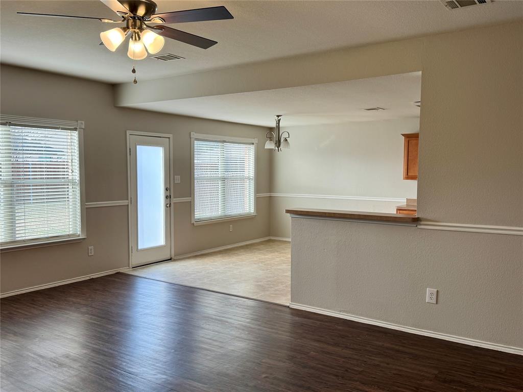 204 South Chestnut Street Forney, TX 75126 - Photo 4 of 19 an empty room with wooden floor chandelier fan and windows