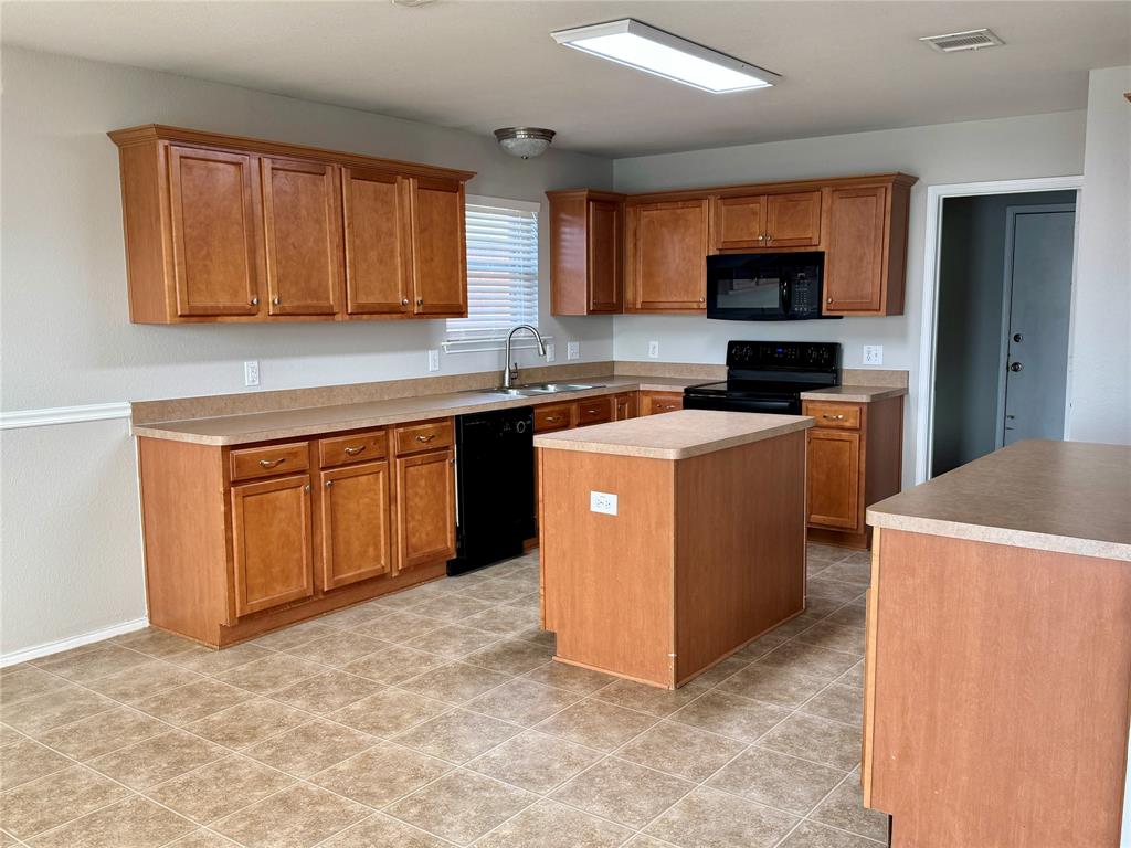 204 South Chestnut Street Forney, TX 75126 - Photo 5 of 19 a kitchen with a sink a stove top oven and white stainless steel appliances