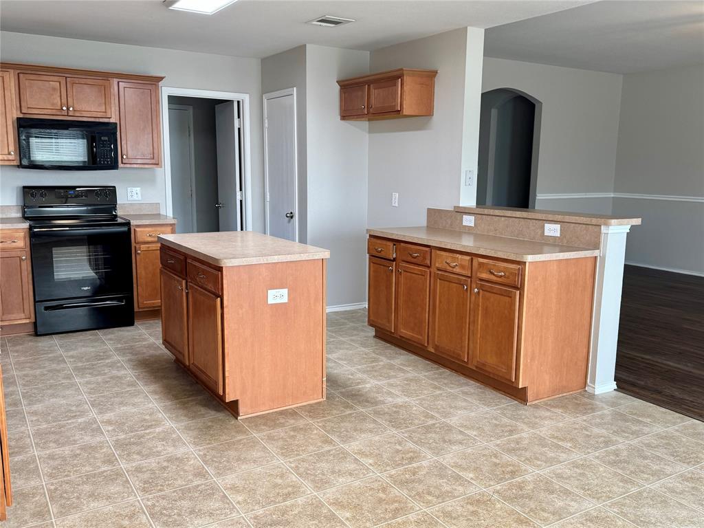 204 South Chestnut Street Forney, TX 75126 - Photo 6 of 19 a kitchen with stainless steel appliances granite countertop a stove top oven and cabinets