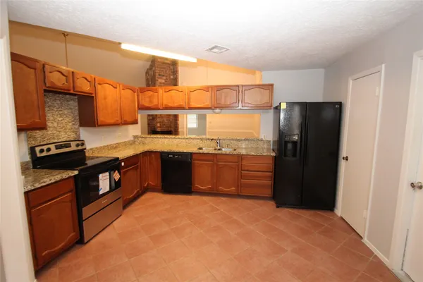 a kitchen with stainless steel appliances granite countertop a refrigerator and a stove