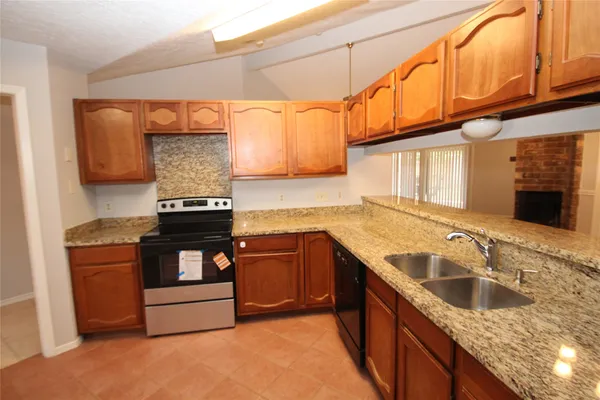 a kitchen with stainless steel appliances granite countertop a sink and a stove