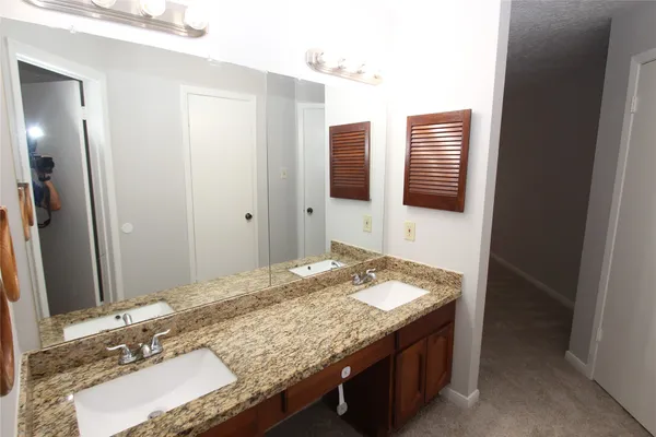 a bathroom with a granite countertop sink and a mirror