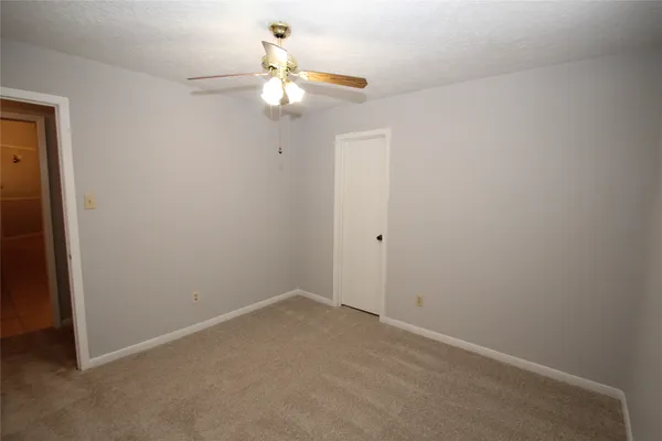 an empty room with a chandelier fan