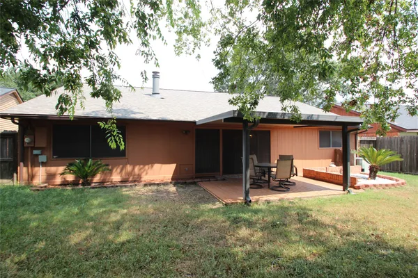 a front view of a house with a garden and tree