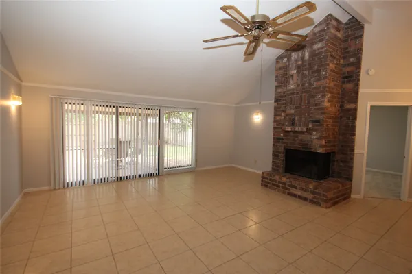 a view of a livingroom with a fireplace and a chandelier fan