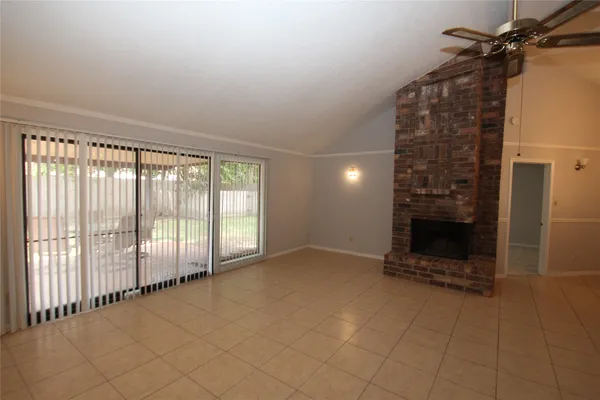 a view of an empty room with a fireplace and a window