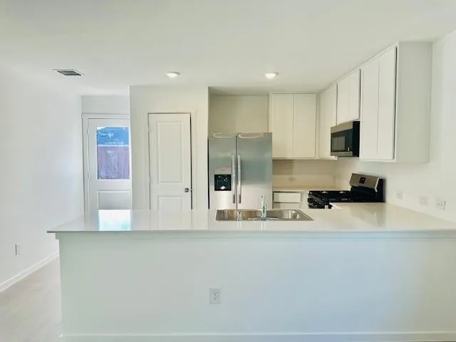 a kitchen with stainless steel appliances granite countertop a refrigerator and a stove