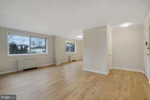 an empty room with wooden floor and window