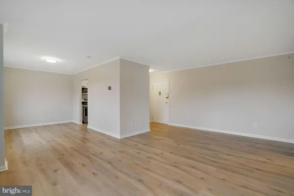 a view of an empty room with wooden floor