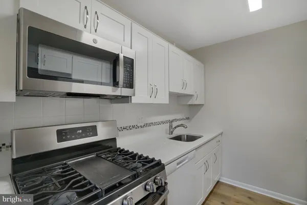 a kitchen with stainless steel appliances granite countertop white cabinets and stove