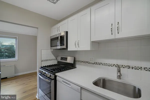 a kitchen with granite countertop white cabinets and a stove