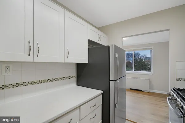 a kitchen with stainless steel appliances granite countertop a refrigerator and a stove