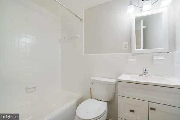 a bathroom with a sink toilet vanity and tub