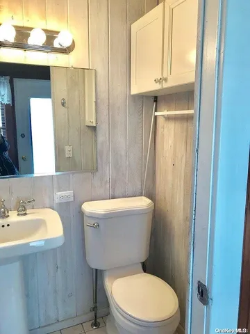 a bathroom with a sink a toilet a mirror and shower