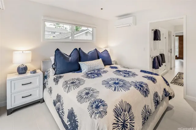 a bedroom with a bed and a lamp on dresser