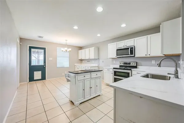 a kitchen with granite countertop a stove sink and cabinets