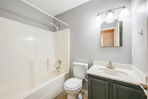 a bathroom with a sink toilet vanity and shower