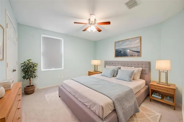 a bedroom with a large bed and a chandelier