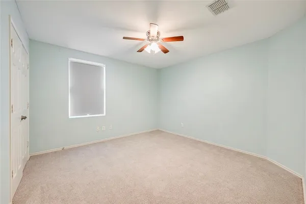 an empty room with windows and ceiling fan
