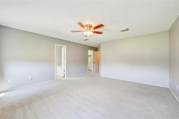 a view of a big room with a ceiling fan and a window