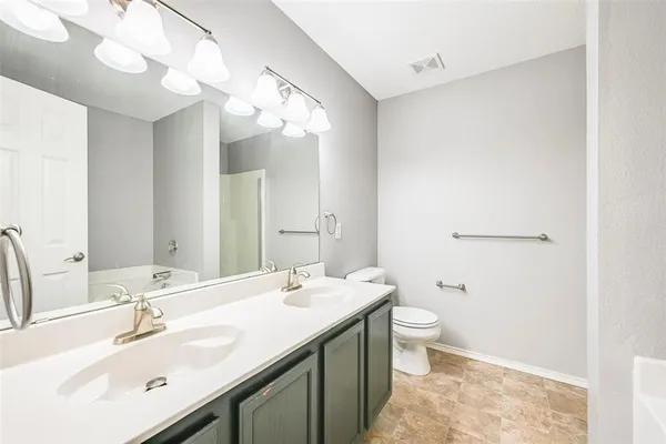 a bathroom with a double vanity sink mirror and toilet