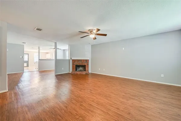 a view of an empty room with a kitchen and a window