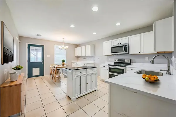 a kitchen with white cabinets and appliances