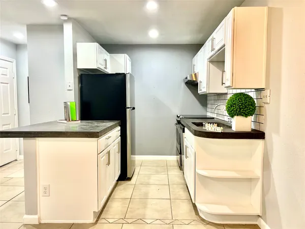 a kitchen with stainless steel appliances a stove a refrigerator and a microwave