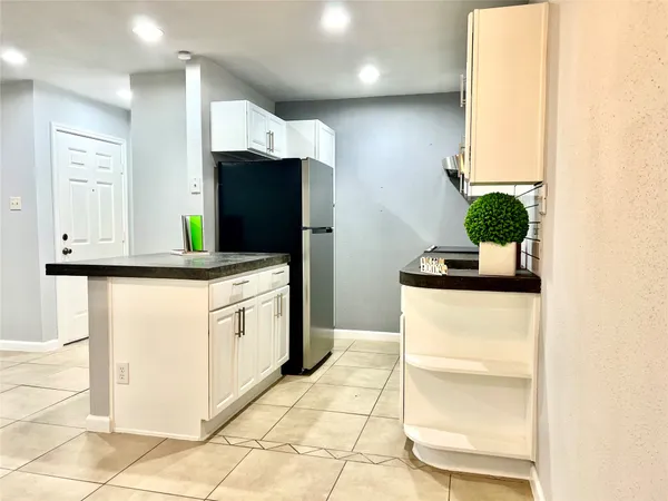a kitchen with stainless steel appliances kitchen island granite countertop a refrigerator and a sink