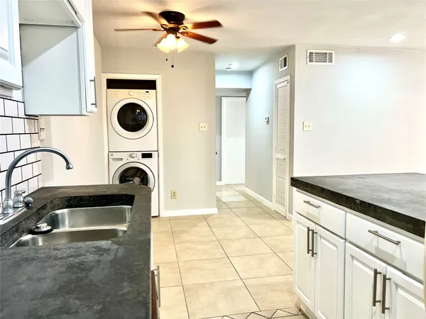 a view of a kitchen with a sink and a stove top oven with a dishwasher