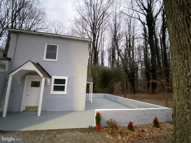 a view of a white house with a yard and large tree
