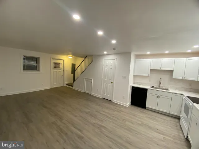 a view of large kitchen with a sink and dishwasher a oven with wooden floor