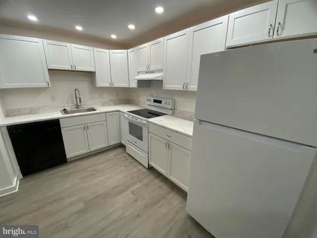 a kitchen with a sink a stove a refrigerator and cabinets