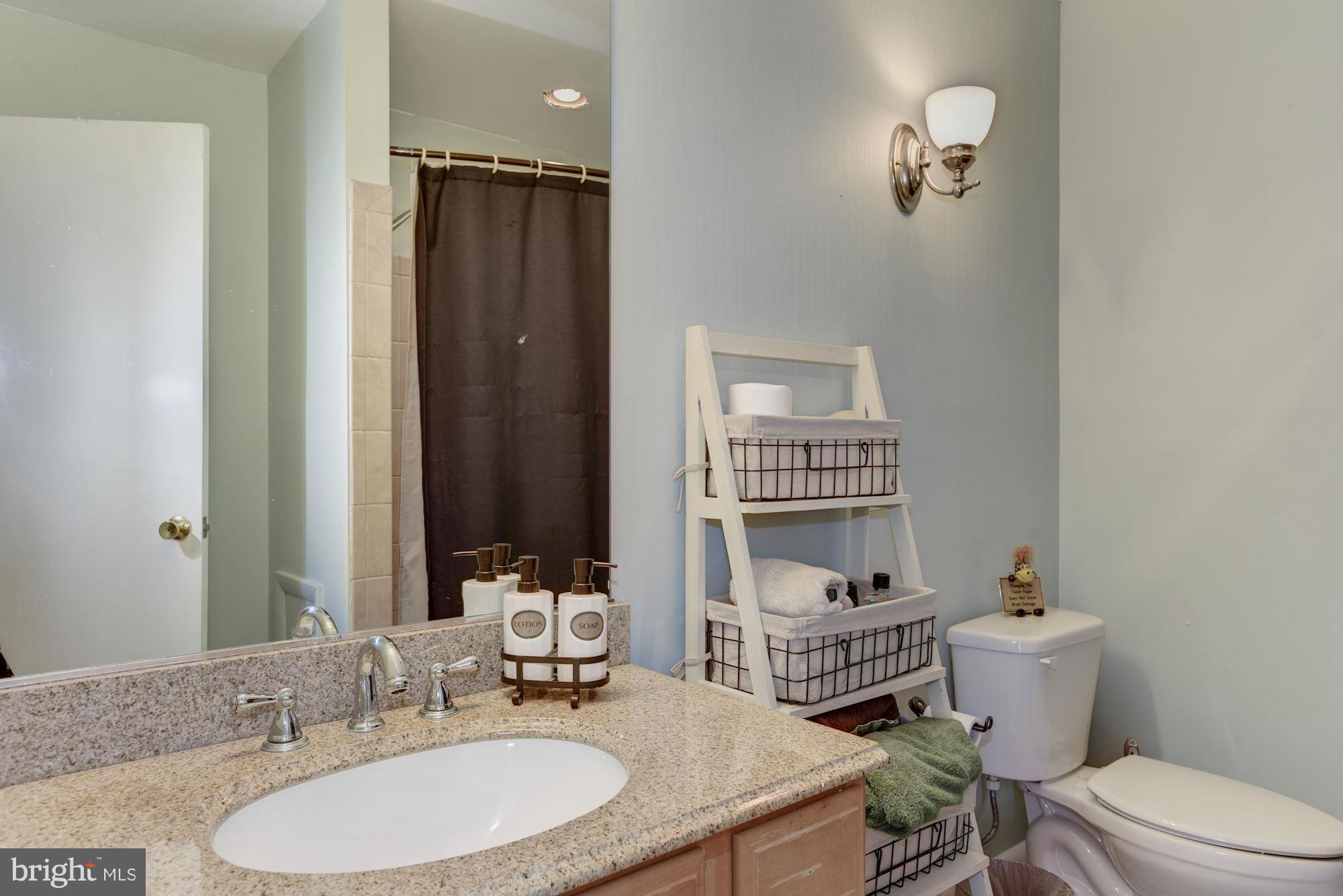 16869 Ivandale Road Hamilton, VA 20158 - Photo 12 of 21 a bathroom with a granite countertop sink toilet a mirror and shower