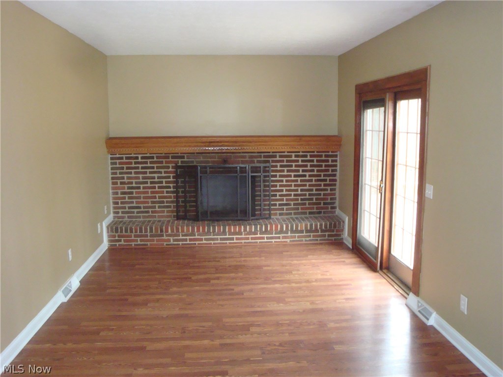 9740 Ridgeview Trail Mentor, OH 44060 - Photo 3 of 30 FAMILY ROOM OVERLOOKING KITCHEN AND BACKYARD. RAISED HEARTH BRICK WOODBURNING FIREPACE. NEW PERGO LAMINATE. PELLA SLIDER