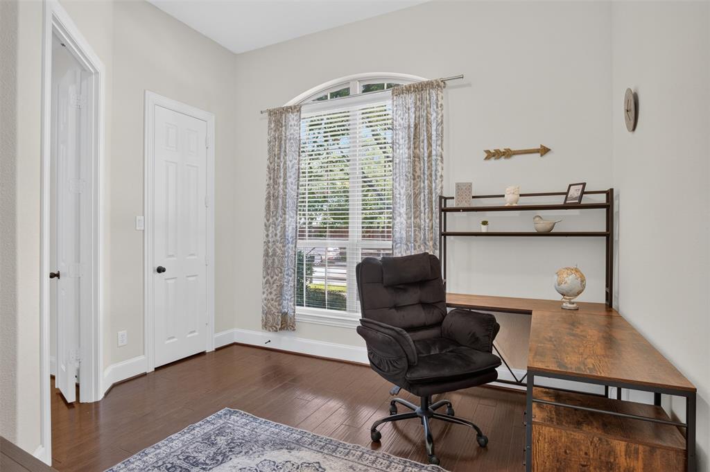 842 Sun Meadow Road Allen, TX 75013 - Photo 29 of 39 Room featuring dark wood-finish flooring, light-colored walls, and a large arched window with blinds