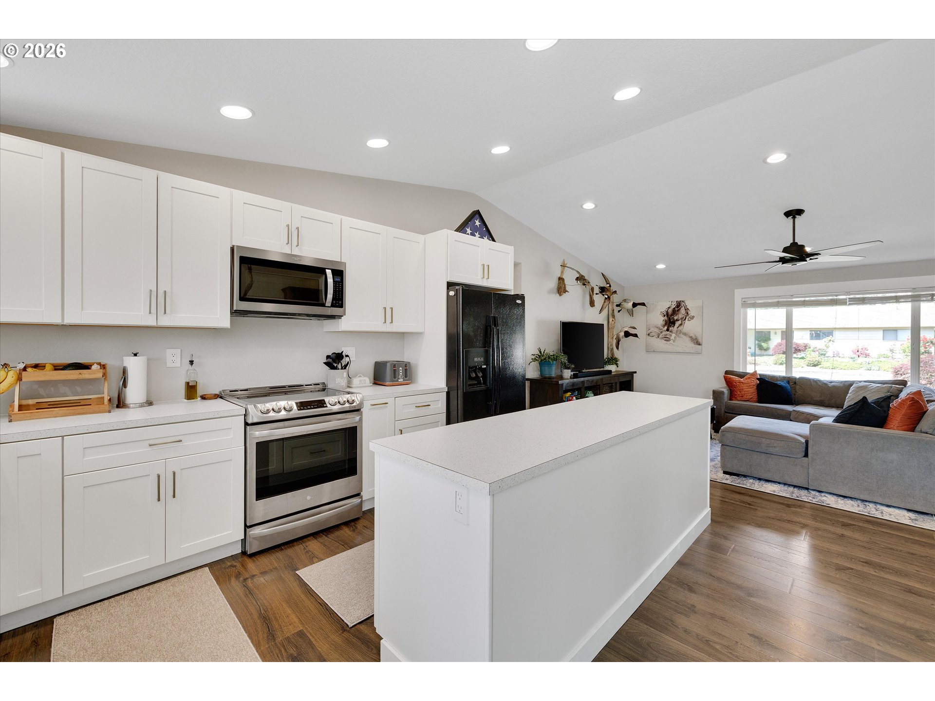 1144 North Pine Street Canby, OR 97013 - Photo 12 of 41 a large white kitchen with stainless steel appliances granite countertop lots of white cabinets a stove a sink a refrigerator and a living room view