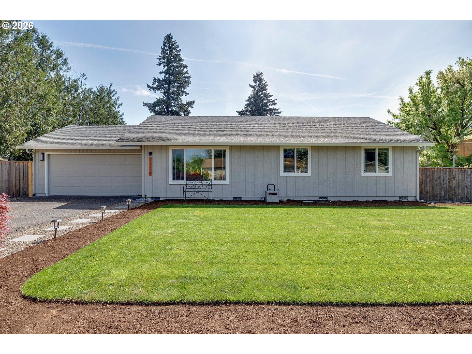 1144 North Pine Street Canby, OR 97013 - Photo 2 of 41 a front view of a house with a garden