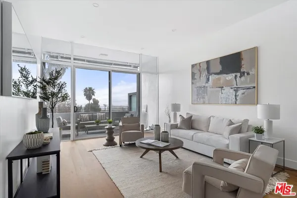 a living room with furniture and a floor to ceiling window